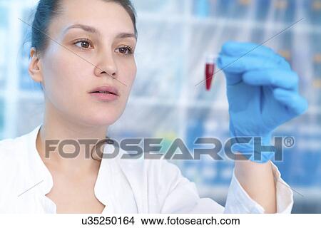 Picture - Scientist holding eppendorf tube in laboratory. Fotosearch