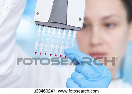 Stock Photo - Scientist holding multi pipette. Fotosearch