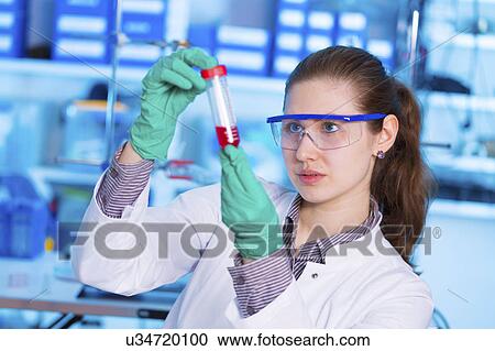 Stock Image - Scientist holding test tube. Fotosearch