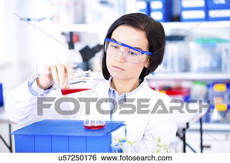 Scientist pouring sample into beaker View Large Photo Image Stock Photograph - Scientist pouring sample into beaker. Fotosearch
