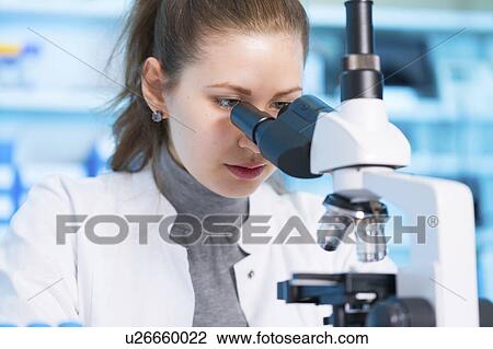 Stock Image - Scientist using microscope. Fotosearch