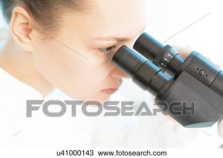 Stock Image - Scientist using microscope. Fotosearch