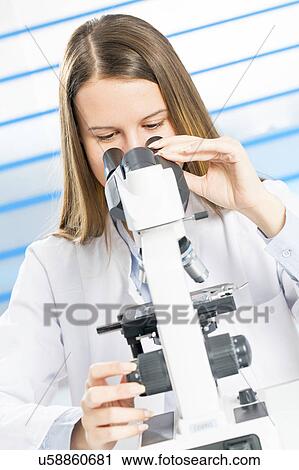 Stock Image - Scientist using microscope. Fotosearch
