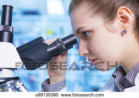 Stock Image - Scientist using microscope. Fotosearch