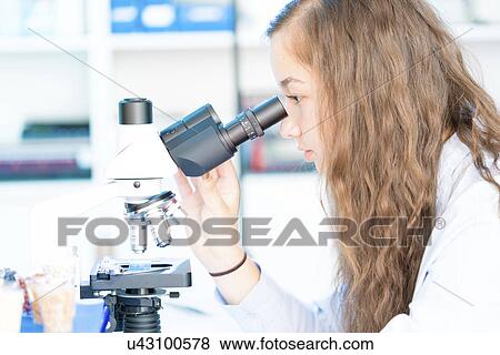 Stock Photo - Scientist using microscope. Fotosearch