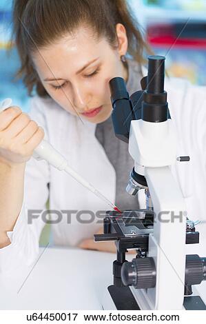 Stock Photo - Scientist using microscope. Fotosearch