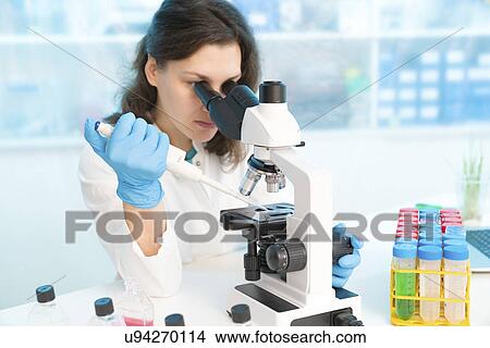 Scientist using pipette and microscope View Large Photo Image Picture - Scientist using pipette and microscope. Fotosearch