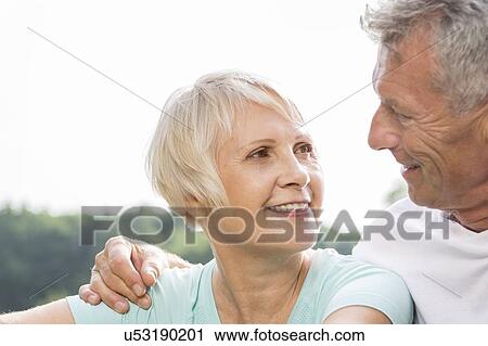 Stock Image - Senior couple smiling, man with arm around woman. Fotosearch