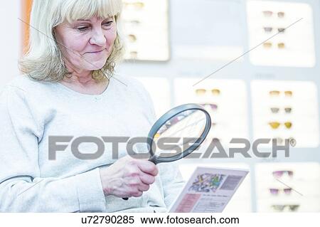 Senior woman holding magnifying glass View Large Photo Image Stock Photography - Senior woman holding magnifying glass. Fotosearch