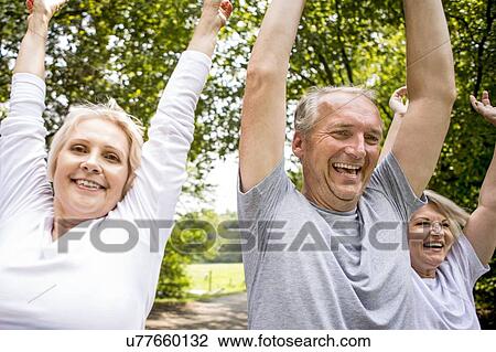 Three people with arms raised, candid portrait View Large Photo Image Stock Image - Three people with arms raised, candid portrait. Fotosearch
