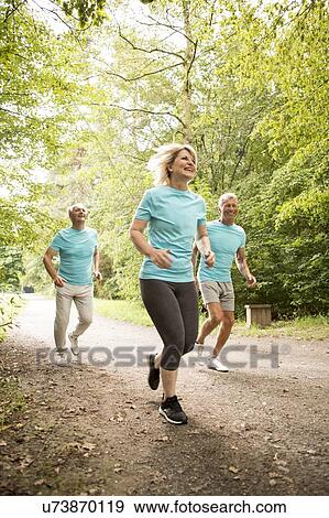 Stock Photo - Three senior people running, smiling. Fotosearch