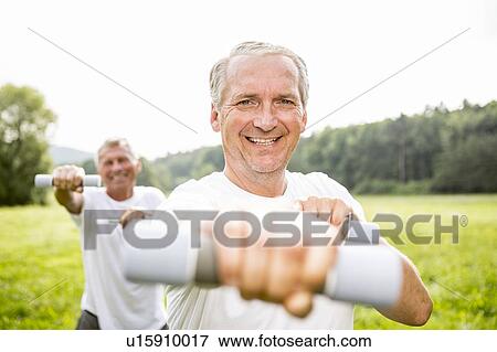 Stock Photo - Two men exercising with hand weights. Fotosearch