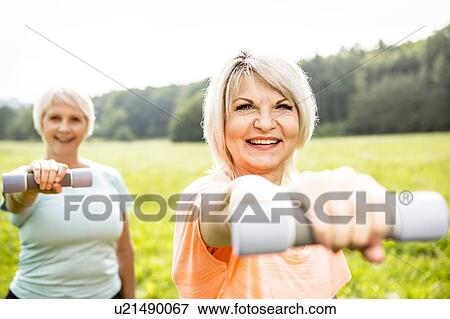 Two women exercising with hand weights View Large Photo Image Stock Photo - Two women exercising with hand weights. Fotosearch