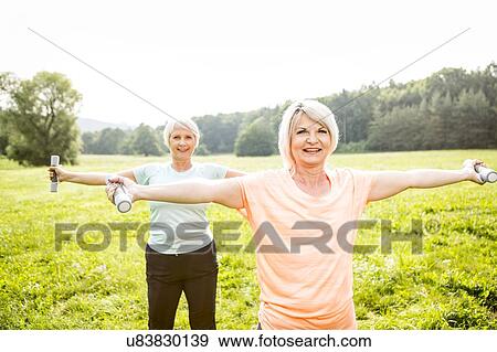 Stock Photo - Two women exercising with hand weights. Fotosearch