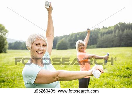 Two women exercising with hand weights View Large Photo Image Stock Photography - Two women exercising with hand weights. Fotosearch