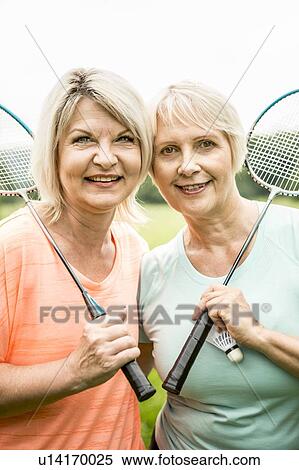 Stock Photography - Two women holding badminton rackets, smiling. Fotosearch
