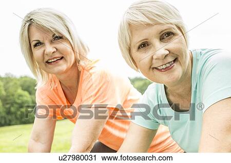 Two women smiling towards camera, smiling View Large Photo Image Stock Image - Two women smiling towards camera, smiling. Fotosearch