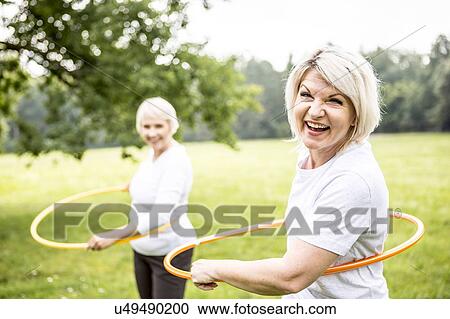 Stock Image - Two women with plastic hoops. Fotosearch