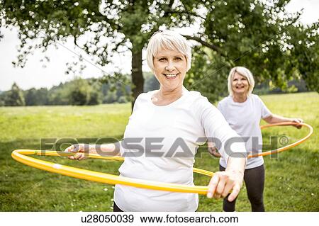 Two women with plastic hoops View Large Photo Image Stock Photo - Two women with plastic hoops. Fotosearch