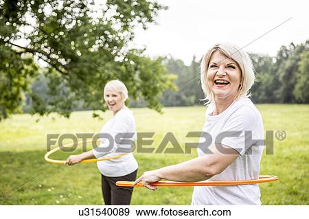 Stock Photo - Two women with plastic hoops. Fotosearch