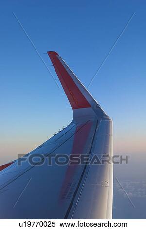 Stock Photography - Winglet on a passenger airliner cruising at high altitude. Winglets improve the efficiency of the wing by reducing the lift-induced drag caused by wingtip vortices. Fotosearch
