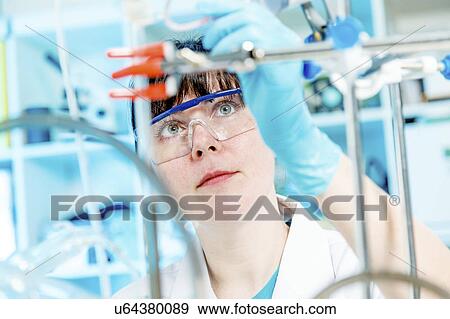 Stock Photo - Woman doing experiment in chemical laboratory. Fotosearch