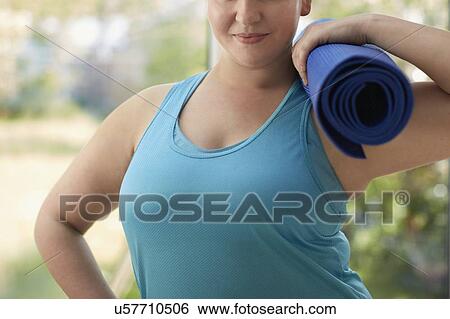 Woman holding yoga mat View Large Photo Image Stock Photograph - Woman holding yoga mat. Fotosearch