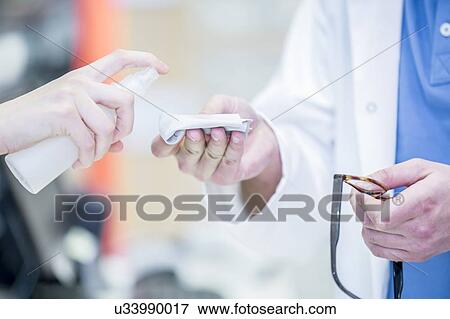 Woman spraying liquid on lens cloth, close-up. View Large Photo Image Stock Photo - Woman spraying liquid on lens cloth, close-up.. Fotosearch