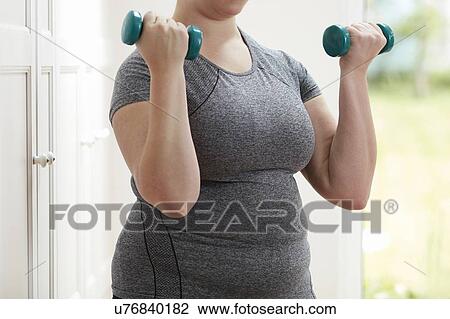 Stock Image - Woman using hand weights. Fotosearch