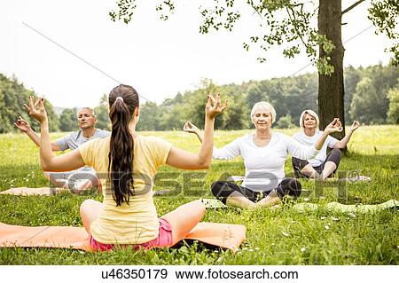 Stock Photo - Yoga class in field. Fotosearch