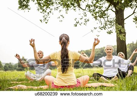 Stock Photo - Yoga class in field. Fotosearch