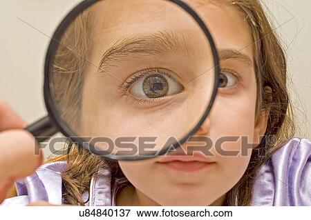Stock Photo - Young girl and magnifying glass. Fotosearch