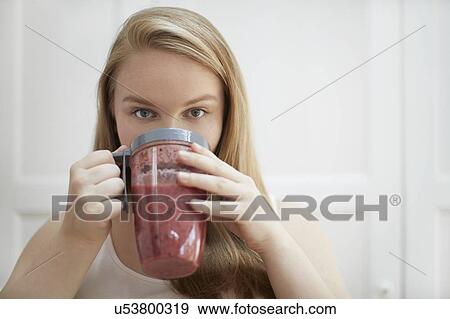 Young woman drinking homemade smoothie View Large Photo Image Stock Photo - Young woman drinking homemade smoothie. Fotosearch