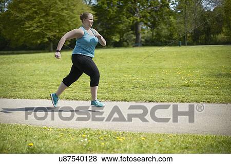 Stock Photo - Young woman running on path. Fotosearch