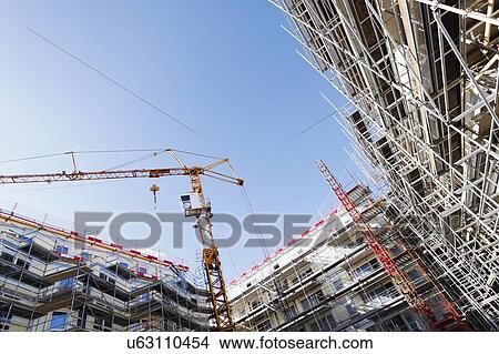 Construction site with cranes and scaffolding View Large Photo Image Picture - Construction site with cranes and scaffolding. Fotosearch