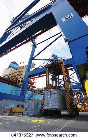 Container crane hoisting cargo onto ship View Large Photo Image Stock Photo - Container crane hoisting cargo onto ship. Fotosearch