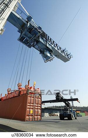 Crane lowering shipping container View Large Photo Image Picture - Crane lowering shipping container. Fotosearch