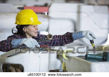 Stock Image - Female engineer working at power plant. Fotosearch
