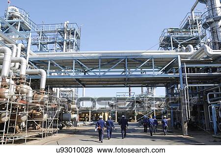 Stock Photo - Industrial workers on oil and gas refinery. Fotosearch
