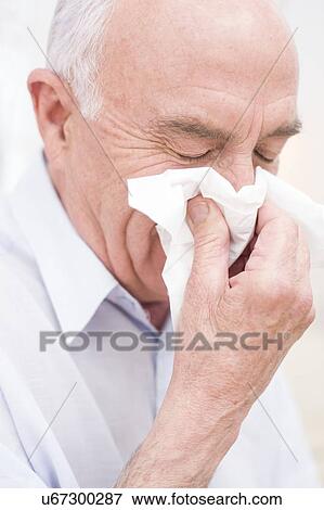 Stock Photo - Man blowing nose on tissue. Fotosearch