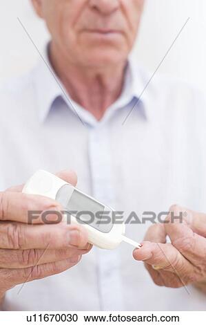 Stock Image - Man testing glucose. Fotosearch