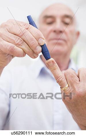 Stock Image - Man testing glucose. Fotosearch