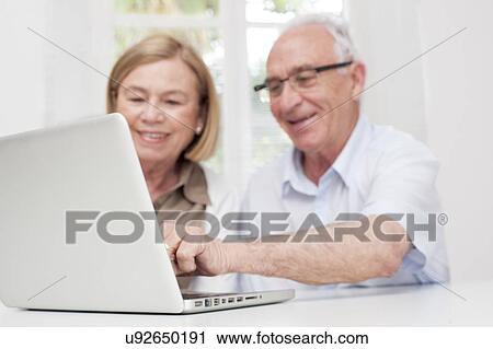 Stock Image - Senior couple using laptop. Fotosearch