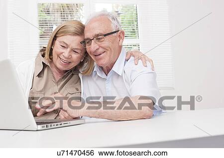 Stock Photograph - Senior couple using laptop. Fotosearch