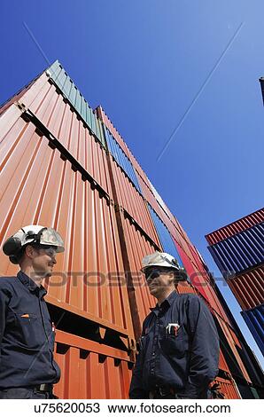 Two industrial workers with shipping containers View Large Photo Image Stock Image - Two industrial workers with shipping containers. Fotosearch