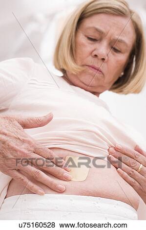 Woman applying hormone patch to tummy View Large Photo Image Stock Photo - Woman applying hormone patch to tummy. Fotosearch