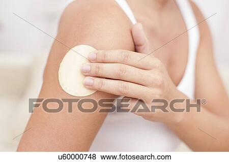 Stock Photo - Woman applying nicotine path to arm. Fotosearch