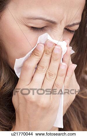 Woman blowing nose on tissue View Large Photo Image Picture - Woman blowing nose on tissue. Fotosearch