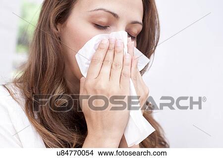 Woman blowing nose on tissue View Large Photo Image Picture - Woman blowing nose on tissue. Fotosearch
