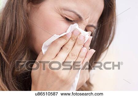 Woman blowing nose on tissue View Large Photo Image Stock Photo - Woman blowing nose on tissue. Fotosearch